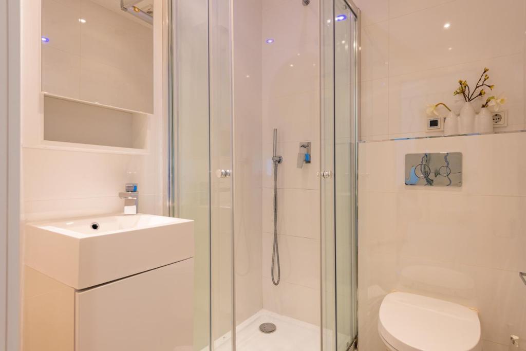 Baño con ducha acristalada, lavabo y aseo