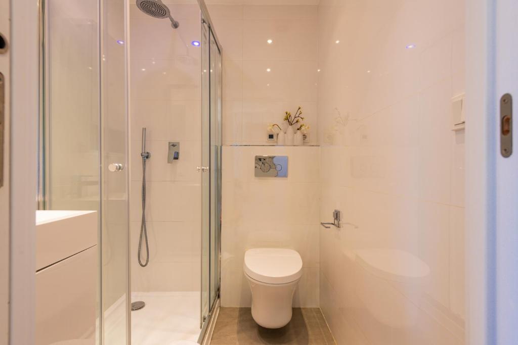 Baño con ducha acristalada, lavabo y aseo